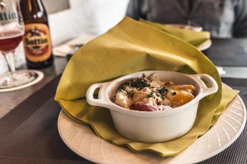 a bowl of food on a plate with a glass of wine at Robbesscheier in Munshausen
