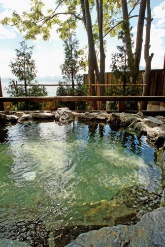 a pool of water in a yard with trees at Shikotsuko Onsen Lake Side Villa SUIMEIKAKU-Adult Only in Chitose