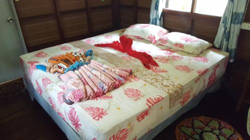 a bed with a white bedspread and pillows on it at Baan Suan Kayoo 2 Buffalo Bay Aow Khao Kwai in Ko Phayam