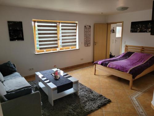 HeidenburgにあるSchöne gemütliche Ferienwohnung im Hunsrückのベッドとテーブルのあるリビングルーム
