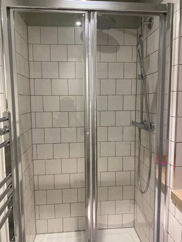 a shower with a glass door in a bathroom at Cosy Box - Room with Ensuite in Croydon