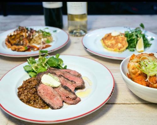 a wooden table with plates of food on it at Cosy Box - Room with Ensuite in Croydon