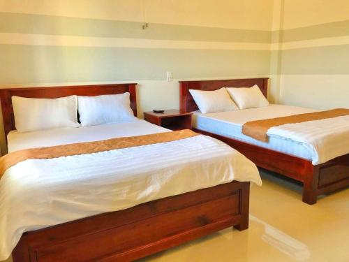 two beds in a room with two beds sidx sidx sidx at Quang Vinh Hồ Tràm in Ho Tram