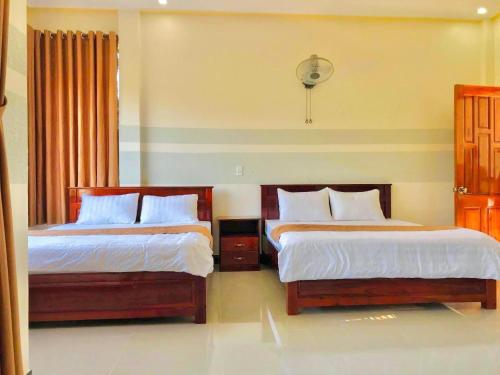 two beds in a hotel room with two bedsskirts at Quang Vinh Hồ Tràm in Ho Tram