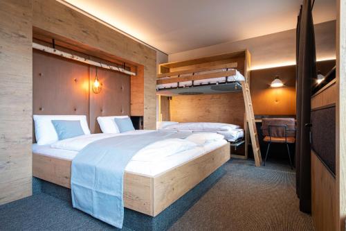 a bedroom with two bunk beds and a desk at RiKu HOTEL Reutlingen in Reutlingen