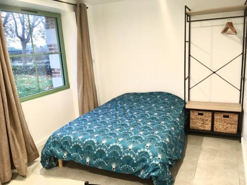 um quarto com uma capa azul numa cama em Angers, La Belle De Maine em Angers