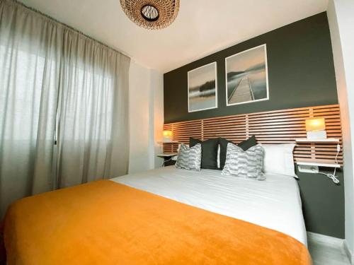 sypialnia z dużym łóżkiem i pomarańczowym kocem w obiekcie Apartamento HARMONY en el centro de Fuengirola w mieście Fuengirola