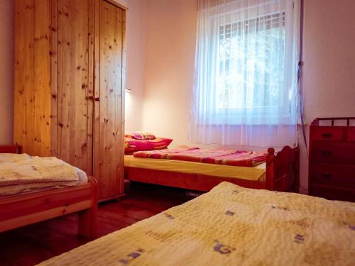 um quarto com três camas e uma janela e uma janela em Apartment for 5 ppl at Lake Balaton em Balatonfenyves
