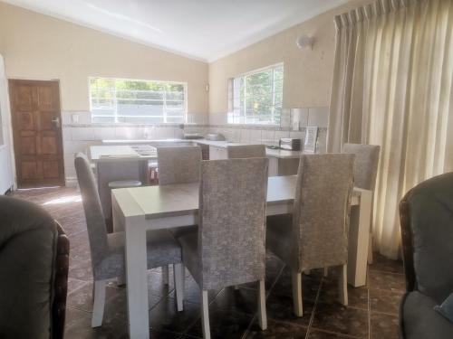 a dining room with a table and chairs at The Calm Views Holiday Home in Hazyview