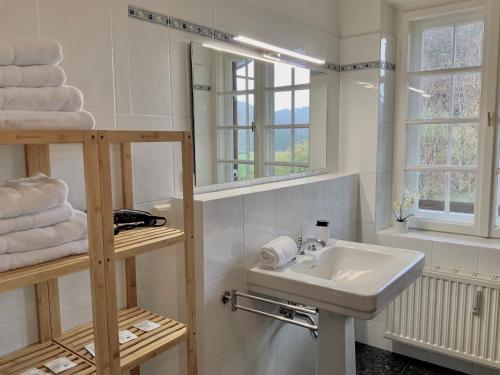 uma casa de banho com lavatório, espelho e toalhas em Edle Altbauwohnung trifft oberbayrisches Bergidyll em Bayrischzell