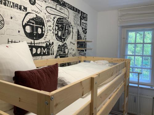 um quarto com uma cama de madeira em frente a uma parede em Edle Altbauwohnung trifft oberbayrisches Bergidyll em Bayrischzell