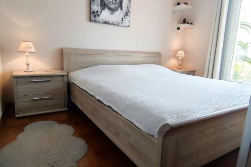 - une chambre avec un lit, 2 tables de nuit et une fenêtre dans l'établissement Belle villa avec vue imprenable., à Fréjus