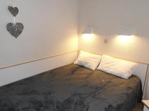 - une chambre dotée d'un lit avec deux oreillers et d'un cœur sur le mur dans l'établissement Appartement cosy au pied des pistes avec balcon et parking - FR-1-181-2040, à La Plagne Tarentaise