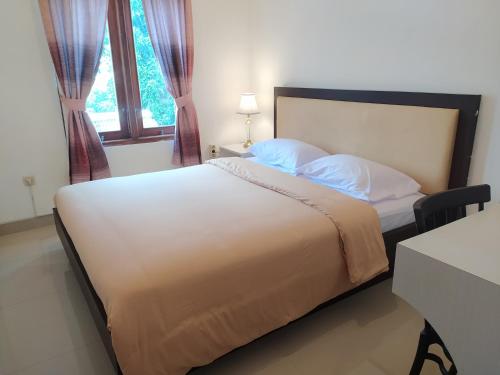 a bedroom with a large bed with a window at House of Soulmate in Demangan