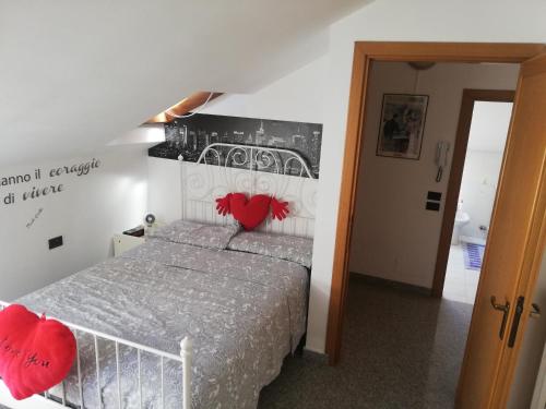 Un dormitorio con una cama con corazones rojos. en La tua mansarda a Bergamo, en Bérgamo