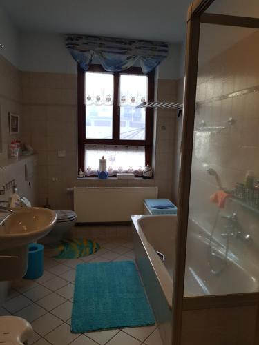 ein Bad mit einer Badewanne, einem WC und einem Fenster in der Unterkunft Apartment Bautzen-Süd in Bautzen
