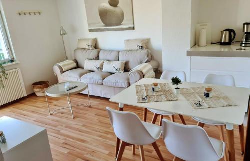 sala de estar con sofá, mesa y sillas en Happy Hero Reisen Ferienwohnungen auf Usedom nahe Achterwasser, en Krummin
