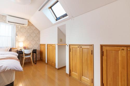 a bedroom with a bed and a desk and a window at Luxury Guest House in Tokyo Shinjuku in Tokyo