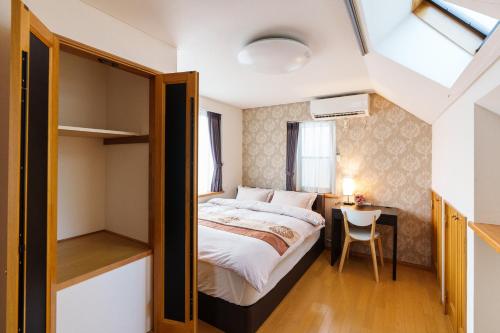 ein kleines Schlafzimmer mit einem Bett und einem Schreibtisch in der Unterkunft Luxury Guest House in Tokyo Shinjuku in Tokio