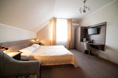 a hotel room with a bed and a television at Рестпарк рекреаційний комплекс in Luts'k