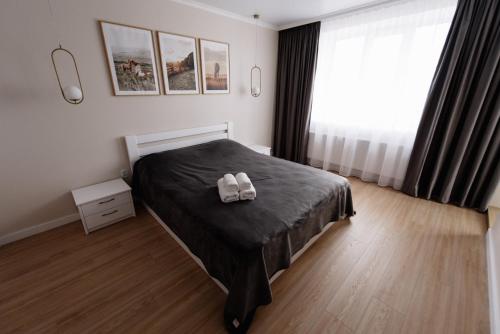 Un dormitorio con una cama con dos zapatos blancos. en Затишна квартира біля парку Центр міста en Ternopilʼ