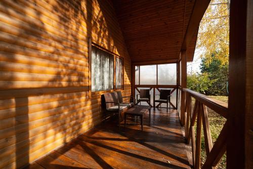 a porch of a house with two chairs and windows at Рестпарк рекреаційний комплекс in Luts'k