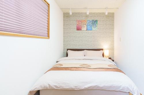 a bedroom with a bed and a window at Luxury Guest House in Tokyo Shinjuku in Tokyo