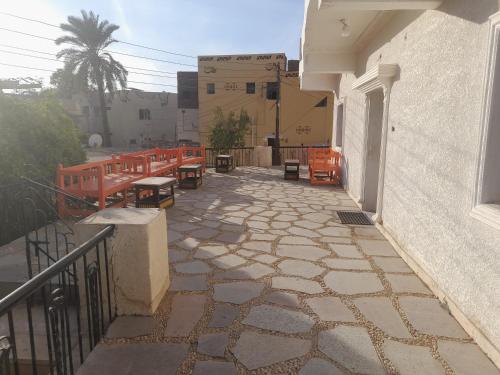 a patio with chairs and tables on a building at Grand house in Nag` el-Ramla