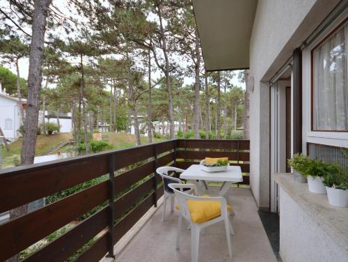 a patio with a table and chairs on a balcony at Villa Liana in Lignano Sabbiadoro
