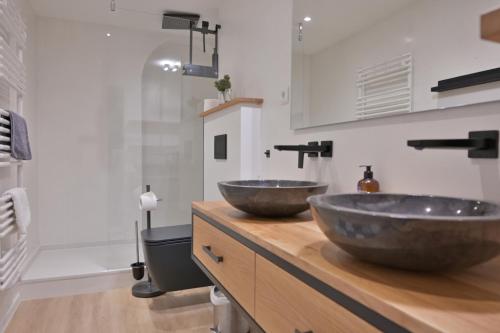 zwei Waschbecken auf einer hölzernen Theke im Bad in der Unterkunft Ferienwohnung STADTBLICK in Flensburg