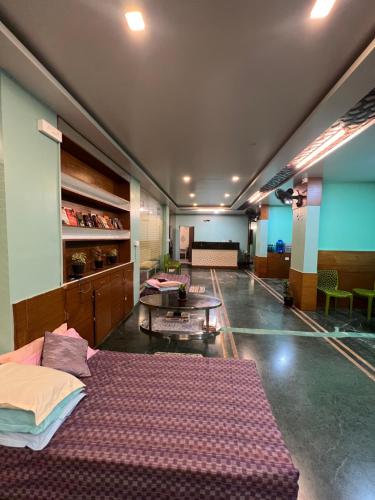 a large room with two beds and a table at Backpackers hostel in Pune