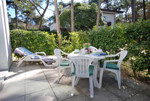 - une table et des chaises blanches sur la terrasse dans l'établissement Villa Liana, à Lignano Sabbiadoro