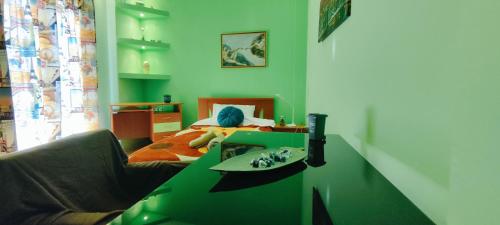 Cette chambre verte comprend un lit et une table verte. dans l'établissement Kelly's Luxury Suite in Thessaloniki's Center, à Thessalonique