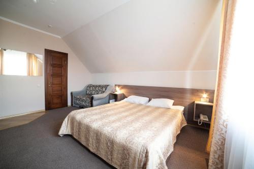 a hotel room with a bed and a chair at Рестпарк рекреаційний комплекс in Luts'k