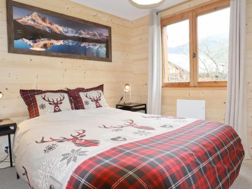 a bedroom with a bed with a red plaid blanket at Chalet Samoëns, 5 pièces, 8 personnes - FR-1-624-118 in Samoëns