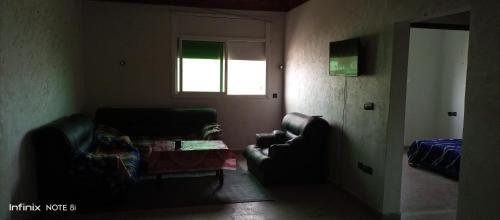 ein Wohnzimmer mit 2 Stühlen und einem Tisch in der Unterkunft Aswa9 salam in Kenitra