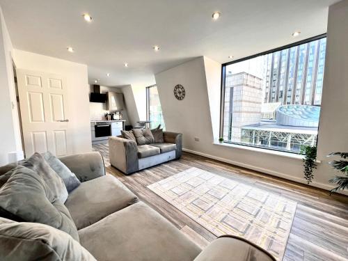 a living room with two couches and a large window at Monthly Stays Liverpool in Liverpool