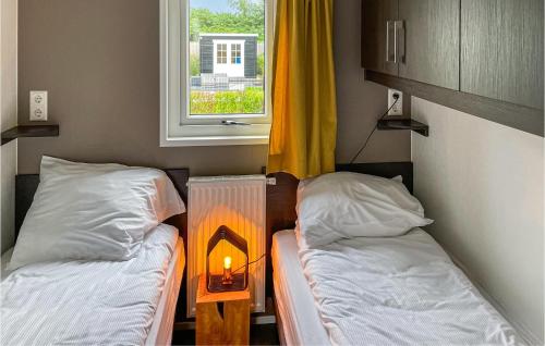 ein kleines Zimmer mit 2 Betten und einem Kamin in der Unterkunft 2 Bedroom Pet Friendly Home In Scherpenisse in Scherpenisse