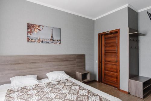 a bedroom with a bed and a picture of the eiffel tower at Рестпарк рекреаційний комплекс in Luts'k