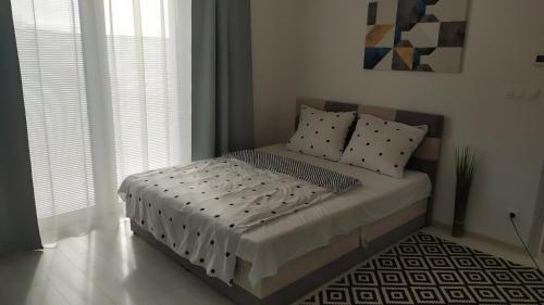 um quarto com uma cama com almofadas em Apartman TILL em Galanta