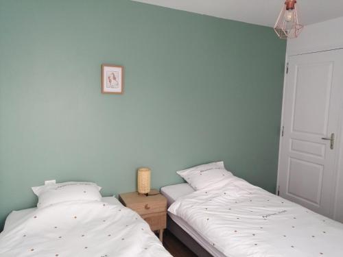 dos camas sentadas una al lado de la otra en un dormitorio en Maison Jullouville au calme, en Jullouville-les-Pins