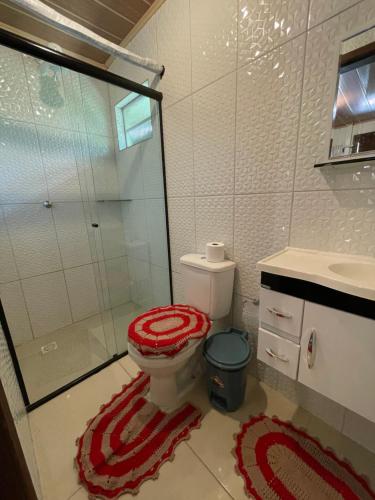 a bathroom with a toilet and a glass shower at Pousada Cair do Sol in Ilha do Mel