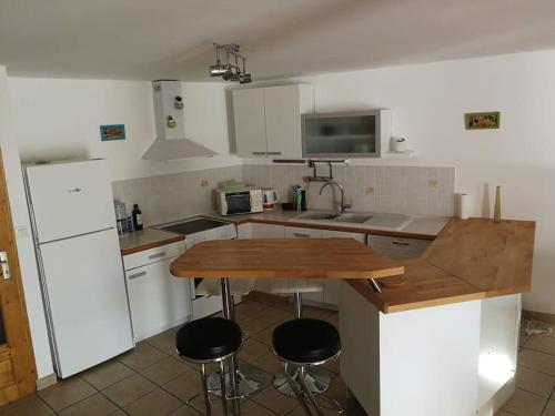 a kitchen with a table and two stools in it at Appartement T4 cosy et familial en bord de pistes in Puy-Saint-Pierre