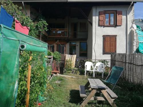 a house with a picnic table and chairs in the yard at Appartement T4 cosy et familial en bord de pistes in Puy-Saint-Pierre