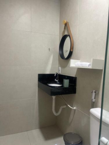 baño con lavabo negro y espejo en SUITES PERTO DO MAR en Porto de Galinhas