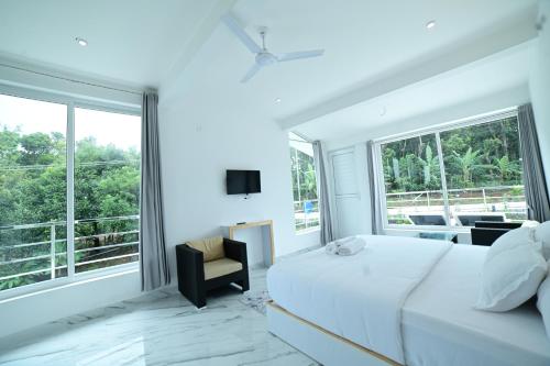 um quarto com uma cama e uma grande janela em RK MOUNT ORCHID coorg em Madikeri