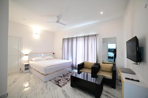 1 dormitorio con 1 cama, TV y sofá en RK MOUNT ORCHID coorg, en Madikeri