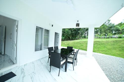 a black table and chairs on a white patio at RK MOUNT ORCHID coorg in Madikeri