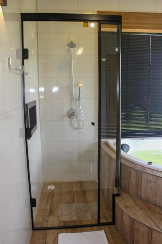 a bathroom with a shower and a bath tub at Chale com Wi-Fi e muito lazer em Bom Retiro SC in Bom Retiro