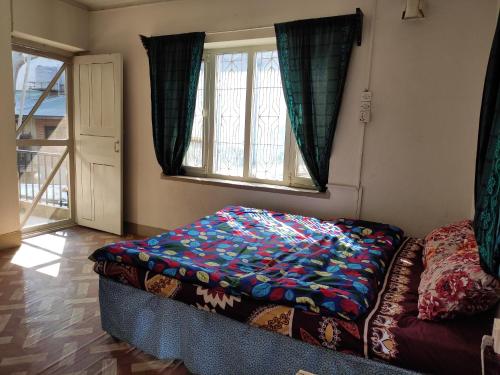 a bed sitting in a room with a window at Laughing Buddha Guest House & Villa in Kathmandu